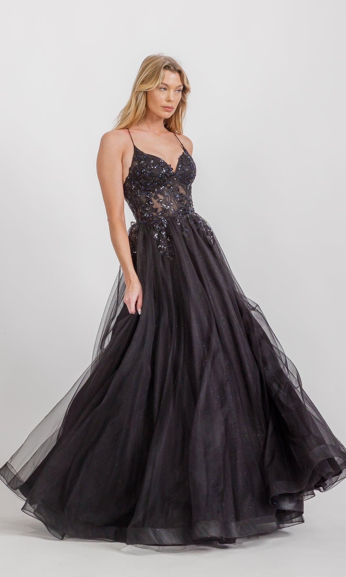 Woman wearing the Lace-Up Corset Long Prom Ball Gown Eureka 9960, featuring spaghetti straps and a sequined semi-sheer bodice, standing against a plain white background.